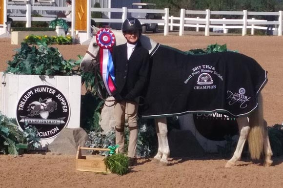 Trilliums horse show champions, Kailey Kaiser and Northwind Snow Angel, posing with ribbons